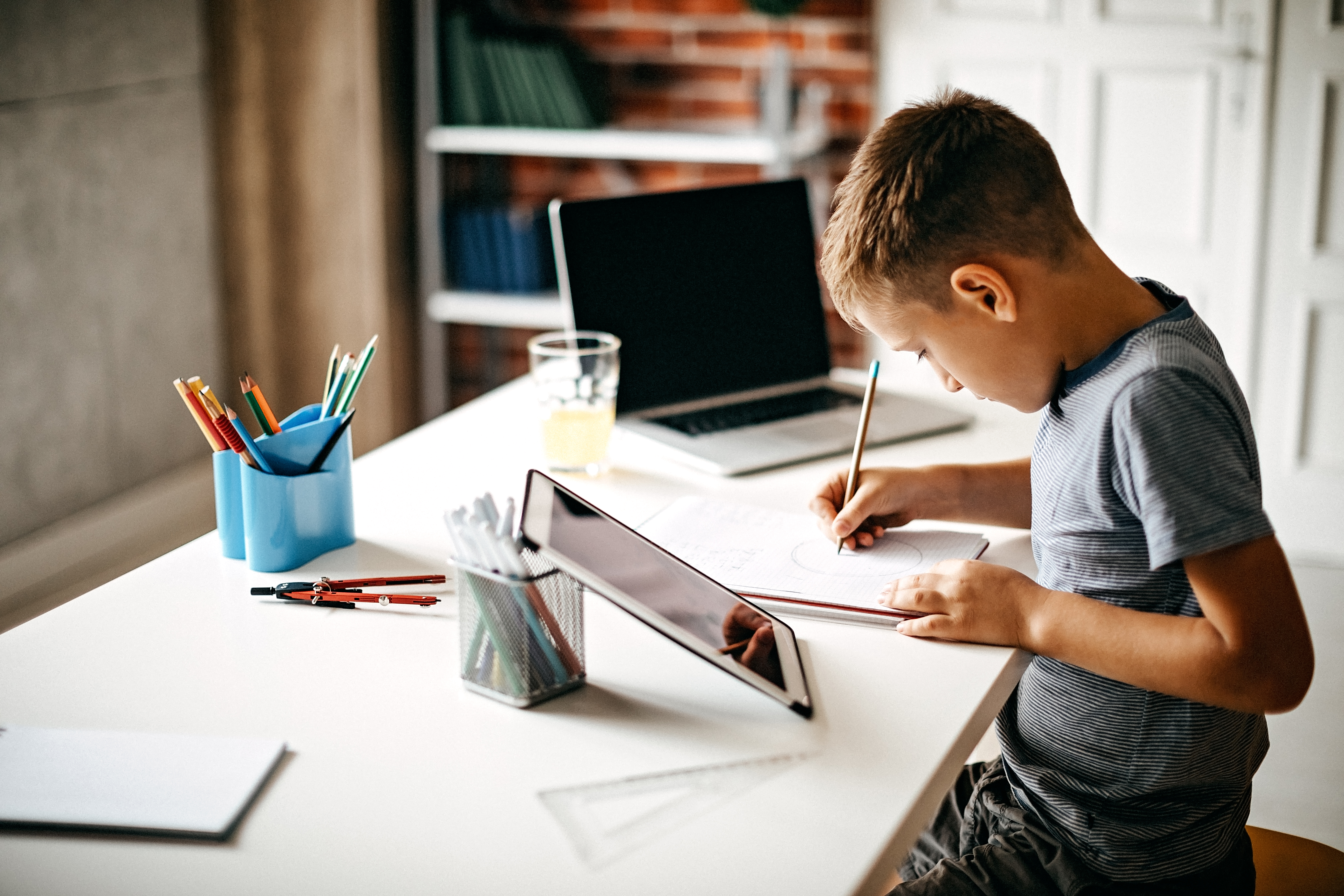 Kid learning for exam on digital tablet and laptop